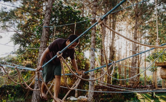 Young man playing on the ropes course