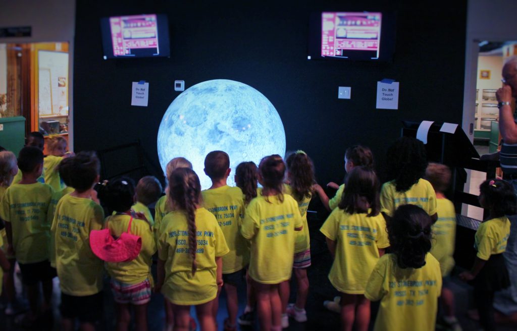 students gathered around the magic planet