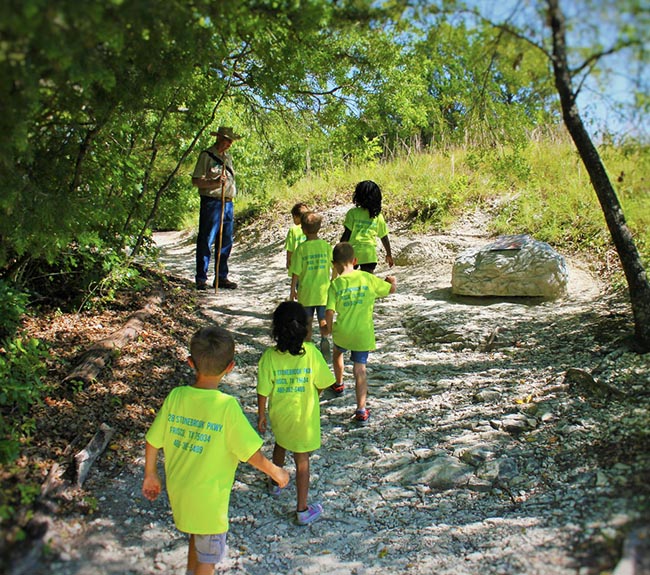 Six children from summer camp on a guided tour with a trail guide