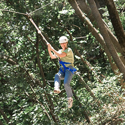 visitor zip lining across the woods