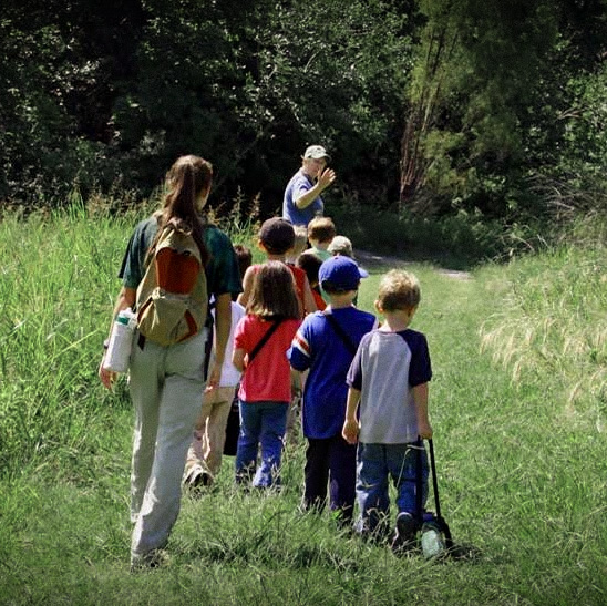 Kids walking the trail with a camp leader during spring break mini camp